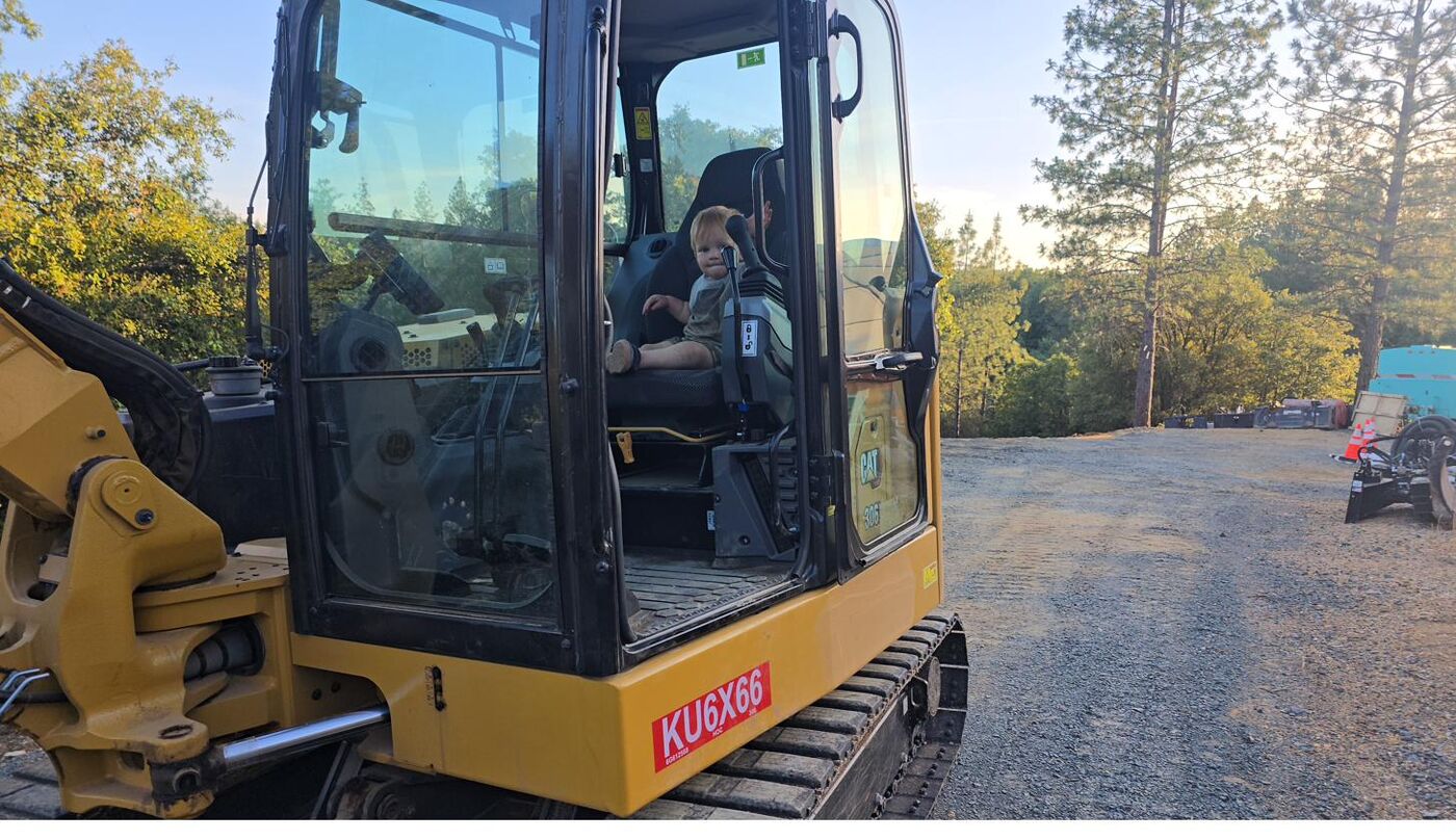 Jax Raniolo in the cab of a CAT 306 excavator