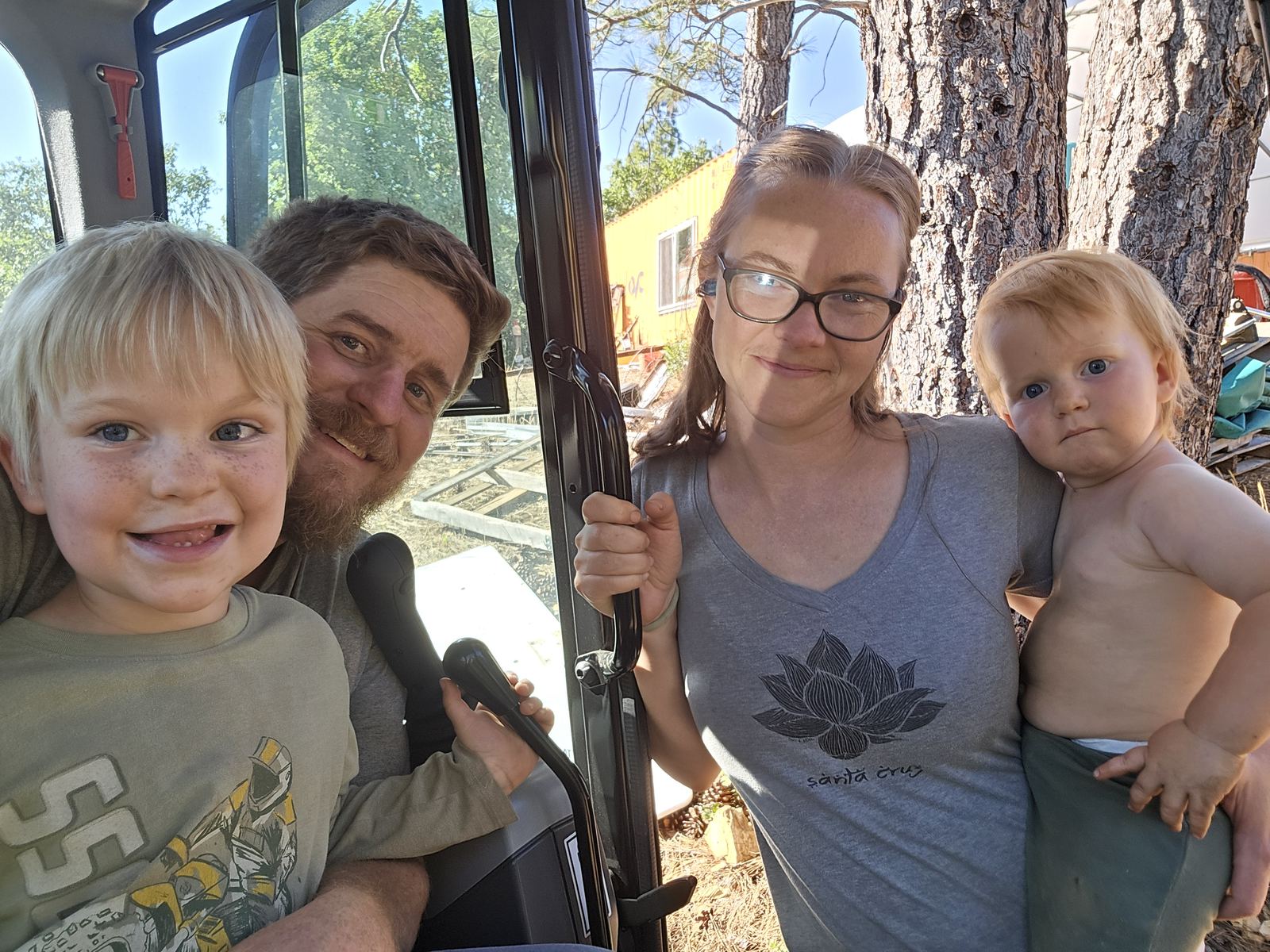 Frank, Katie, Felix, and Jax Raniolo — the Green Constructors family — at the excavator cab on their Colfax property