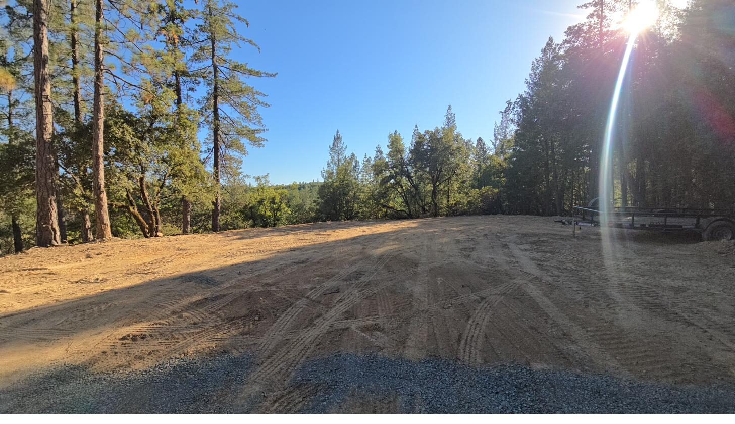 One-acre graded hilltop pad with long-range valley views and cleared forest edge