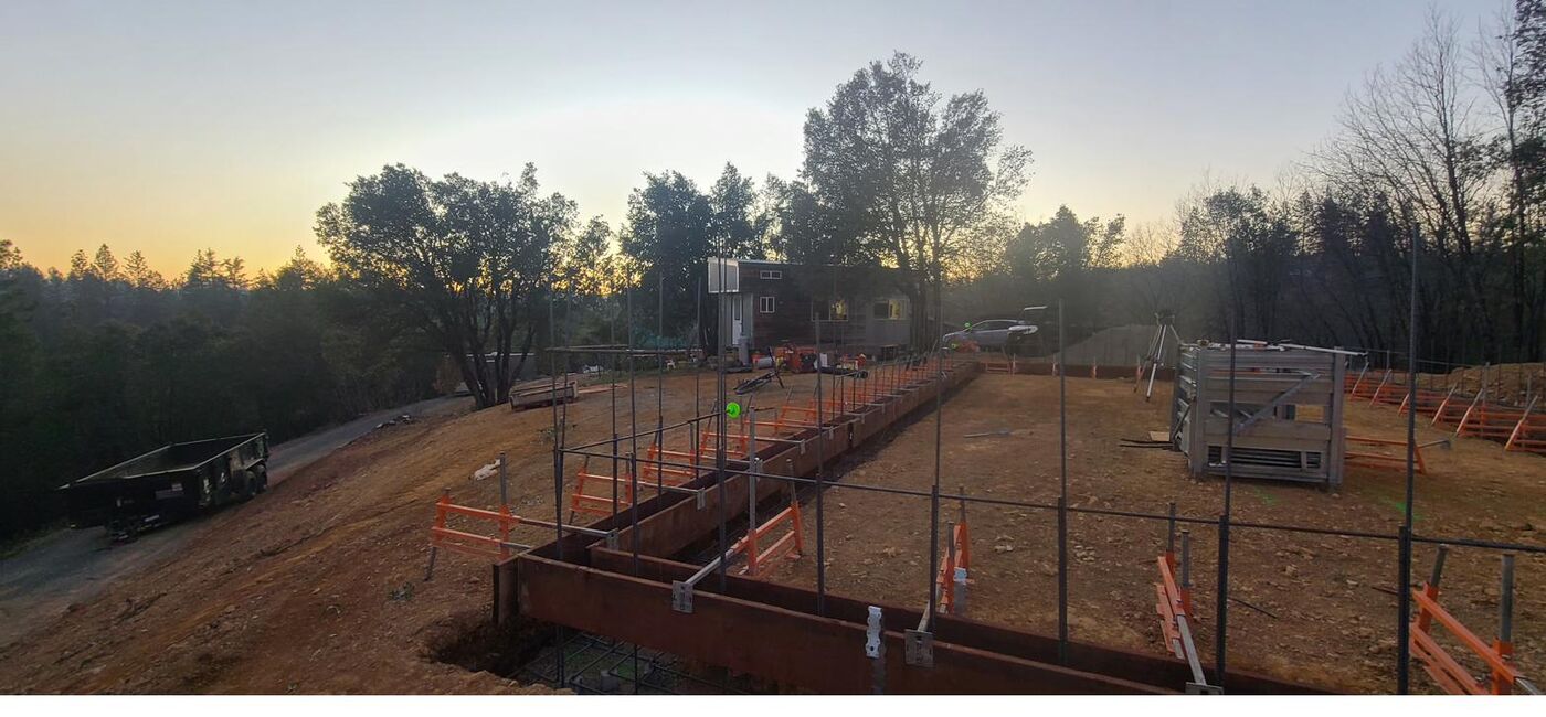 Foundation formwork set on an excavated hillside pad in the Sierra foothills