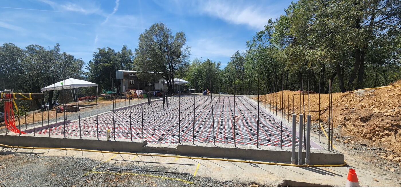 Red PEX hydronic heat tubing laid in long loops across foam insulation panels
