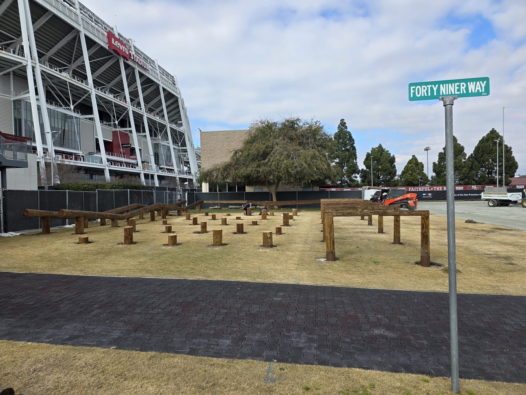 Mid-rebuild of the relocated 49ers obstacle course on Forty Niner Way with Levi's Stadium directly behind, January 2025