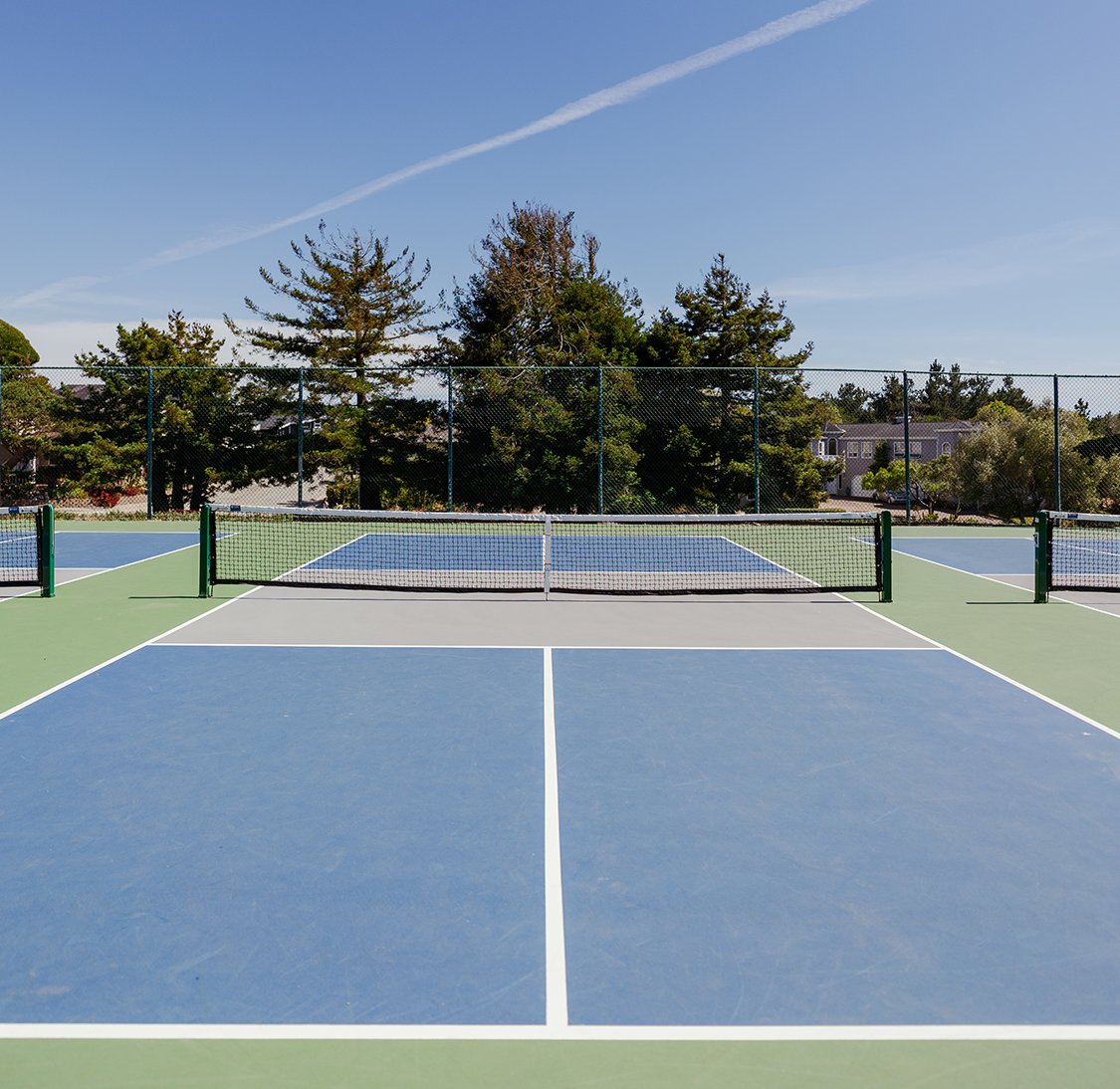 Freshly finished blue and green pickleball courts with new nets and clean line striping